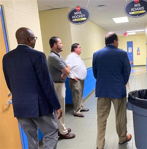 Board members Travis Cummings, Tim Holtcamp and Greg Hulsey in Rainbow Elementary hallway with Dr. Nichols